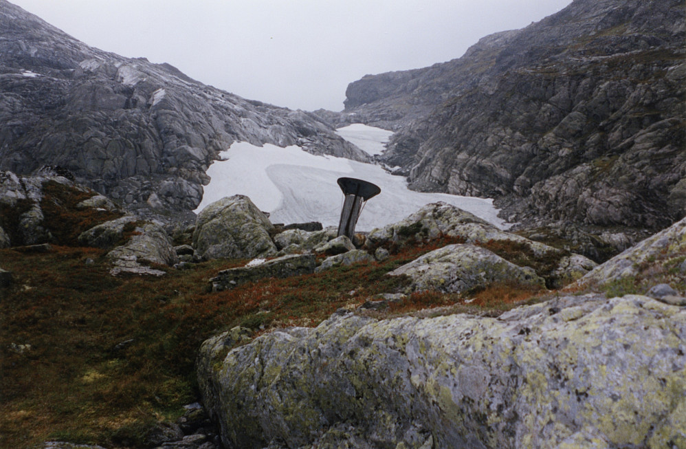 Nedbørsmåleren ved 1141-vannet (Vassmælarvatnet) oppe i dalen mellom Slondalen og Tryglabotnen. Stien ligger delvis skjult under snøfonnen med navnet Brattefonn