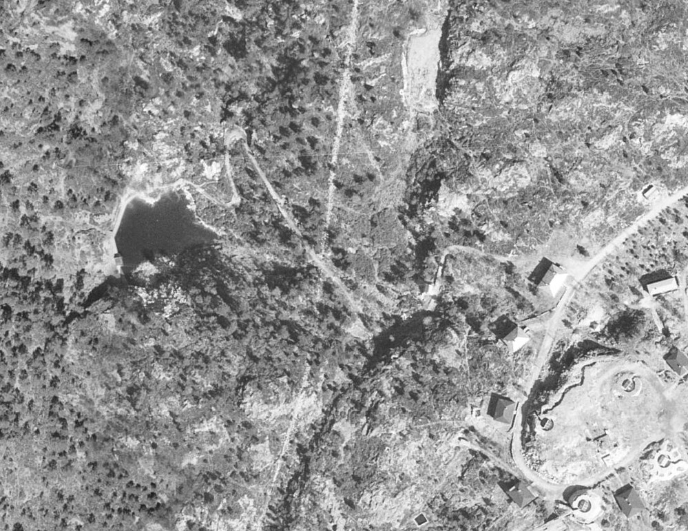 Kart over demningen ved Storrinden. Demningen viser godt på flyfoto fra 1951 fra kart.finn.no. Konturen av et lite hus på sørsiden av demningen vises også.