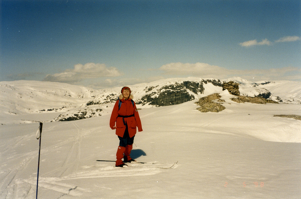 Astrid på Svana. I bakgrunnen den fine varden på ca. 1x1 m som markerer grensen for Statsallmenningen. GPS 32V 391571 6724307, 1387 moh. Skipanuten i bakgrunnen.