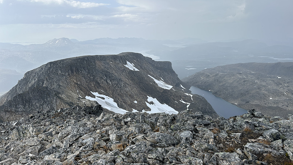 Den litt lavere 988-toppen med såvidt synlig varde. Brevatnet 670 ned mot høyre. I forkant av fjellet ser en området hvor vegetasjonsrennen kommer opp