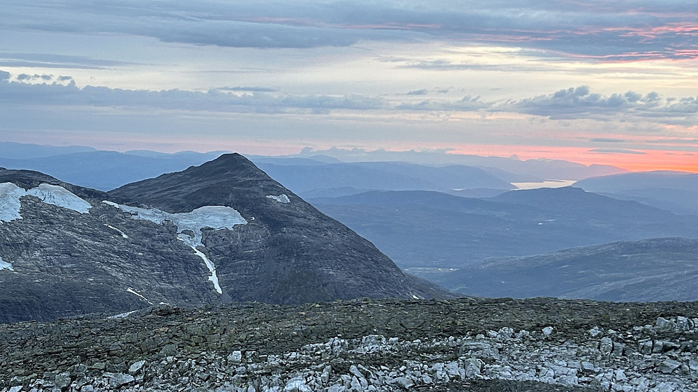 Solnedgang fra toppen av Geitinden. Utsikt mot vest der en ser konturene av De Syv Søstre. Blinkende lys foran søstrene må være fra vindturbinene på Øyfjellet vest for Mosjøen