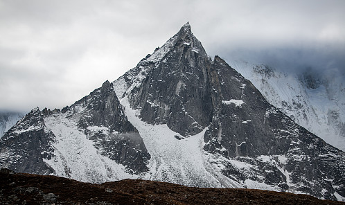 Profilen til Amphu Gyabjen sett fra Chukhung med de høyere fjellene i bakgrunnen inn under tåka