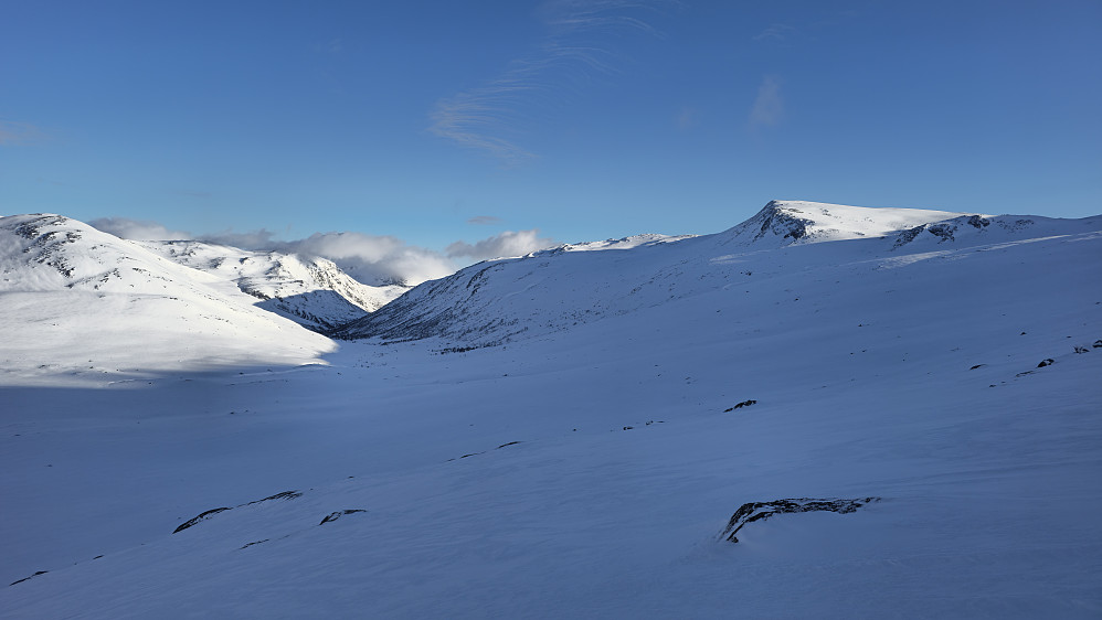 Prøvde å holde høyde og traverserte på tur nord, fremfor å gå i bunnen av dalen nordover. Sparte noen høydemeter på det. Ble glad da jeg "rundet" og kunne se dagens første topp for første gang.