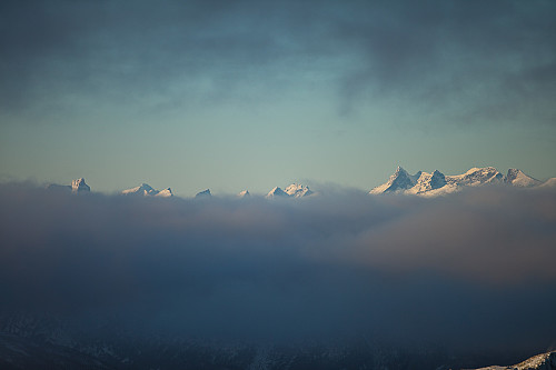 Fra toppen mot Hurrungane som "svever oppå" tåkeskyer over Vangsmjøse.