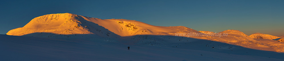 Øystre Rasletinden i morgenglød. Torkjell vandrer der fremme.