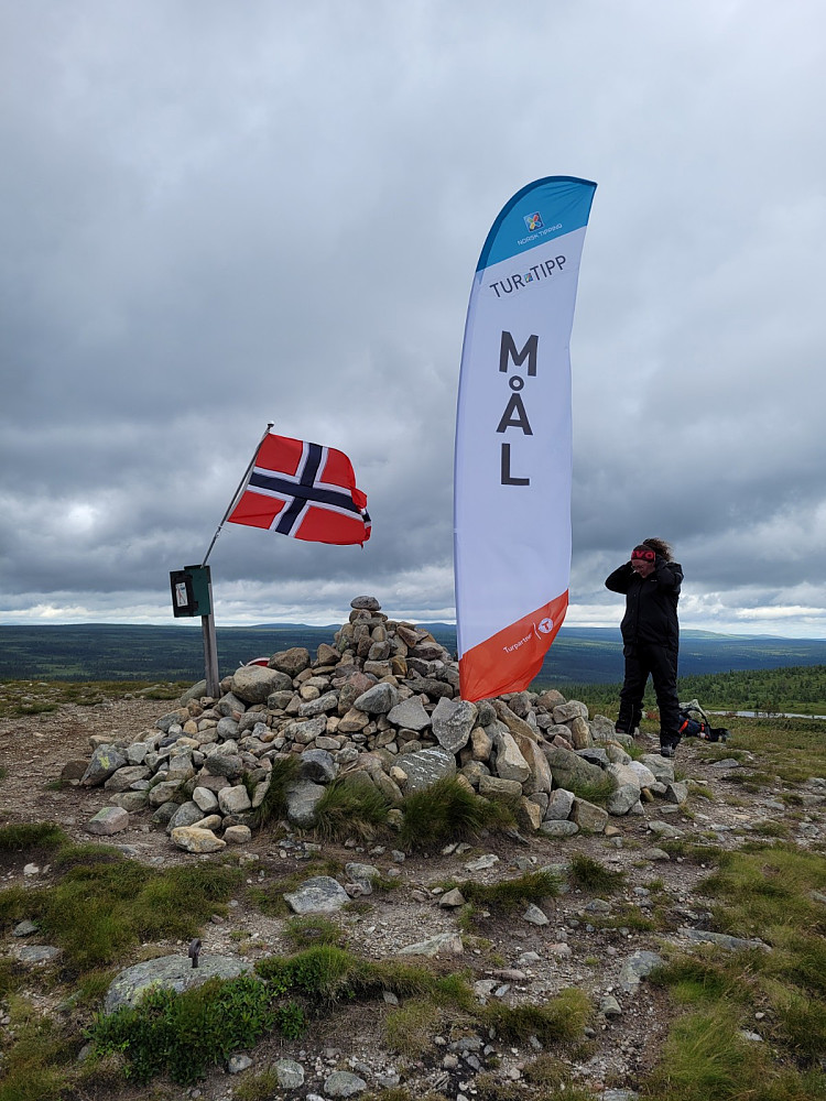 Da har vi fått opp flagg og målbanner på toppen- i sterk vind!