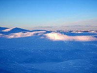 Jotunheimen kan ses bak til høyre. Blant annet Svartdalen med Knutsholstind på høyre side av dalen.