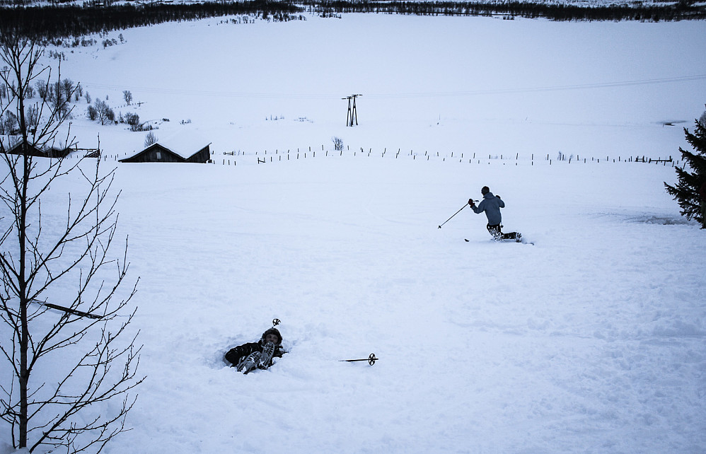 Eirik viser hvordan man skal sette en ekte telemarksving med fjellski. Simen koser seg i snøen.