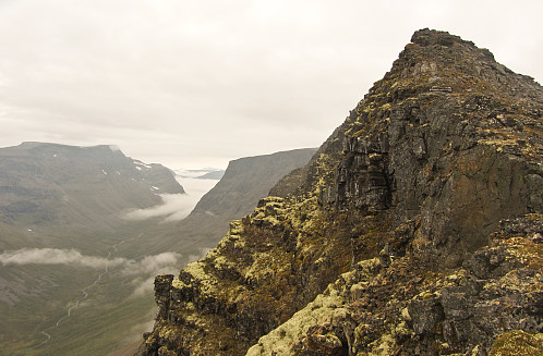 Ryggen opp mot Cahcevahnjunni var litt krunglete med våte og såpeglatte steiner. Vassdalen til venstre. Steile skrenter og flate topplatå er et kjennetegn på fjella i Indre Troms.