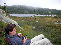 Lunsjpause ved Steintjern (bakgrunnen), Bjørn-Even studerer GPSen over en matbit.