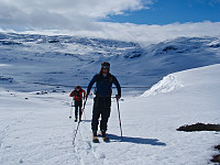 Karl og Henrik koser seg på tur tross tyngre randoutstyr. Kistenuten gjemmer seg bak i tåka. Første stigningen er nå unnagjort.