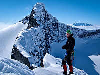 Øyvind poserer foran en av Jotunheimens flotteste egger - Bjørneggen. Lengre bak svever Hurrungane stadig på sitt skyteppe... 