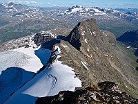 Tilbakeblikk mot Jernskartinden der snørampen med sporene våre strekker seg helt opp på ryggen. Lenger bak ses Kjerringa+Mannen og Stølsnostinden+Falketinden i himmelranden.