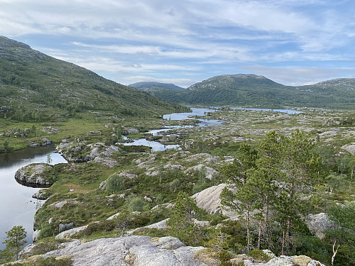 Frå knausen aust for hytta med utsikt nordover Sunnmorkhølen (nærast) og Sunnmorkvatnet under Åsliknuten. Det er ikkje farbart med båt mellom hølen og vatnet, og derfor er det båt begge stader