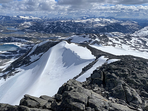Sørlig utsikt mot Smørstabbtindane og Hurrungane, og med Lundadalsbandet nedenfor utløperen fra Midtre Holåtind. I front av Hurrungane brer også Liabrekulen seg utover