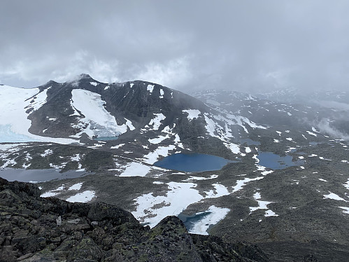 Nedstigning idet skodda siger inn, men med fortsatt utsikt mot Tverrådalskyrkja, Styggvatnet og Steindalstjørnene hvor vi har teltet