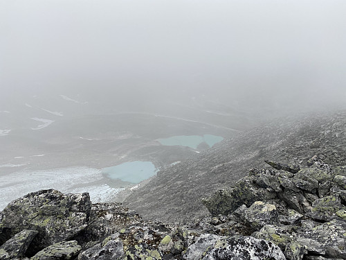 Vi snytes akkurat for utsikten fra toppen, men ser såvidt Nordre Svånåbreen og 1527-tjørna (Ytste Storstyggsvånådalstjørna)