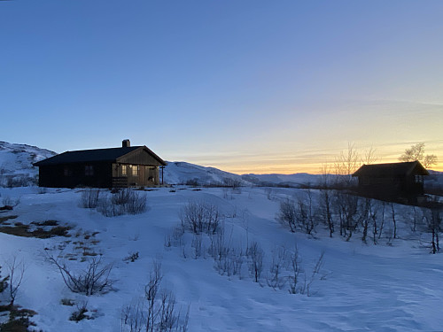Hyttene ligger fint til på et høydedrag; her hovedhytta og uthuset