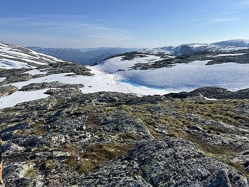 Extremely blue snow melt lake near the peak