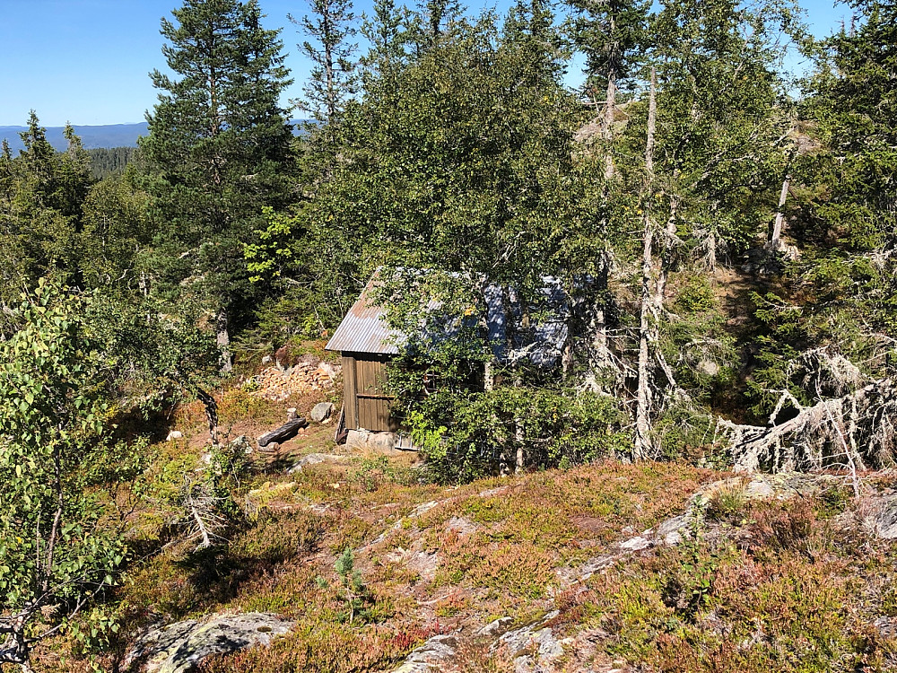 Ei skogshytte nede i sadelen mellom de to høydene på Tannfjell