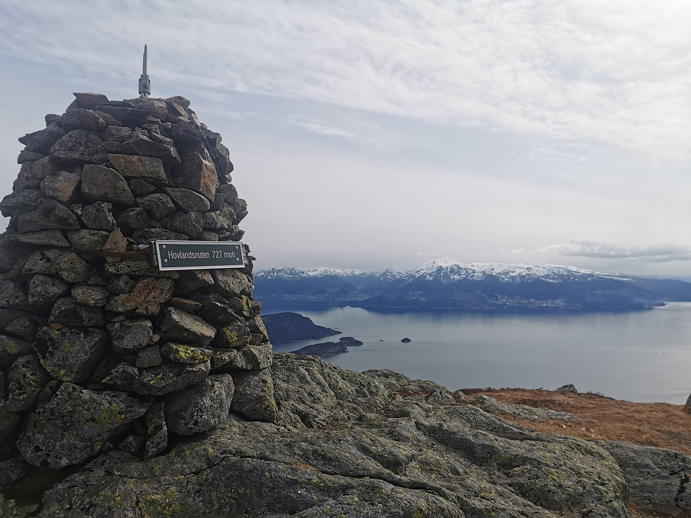 Hovland uten med ytre Hardangerfjorden og en delvis tåke-kledd Ulvanosi i bakgrunnen