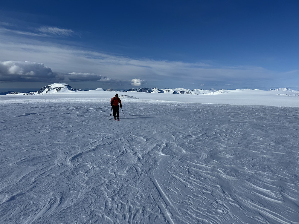 Knut og Solveig mot Snøtinden, like før skiene parkeres. Knausen i bakgrunnen har vi nettopp passert på vestsiden.