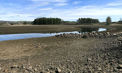 Åkervika med E6 i bakgrunnen. Lite vann.