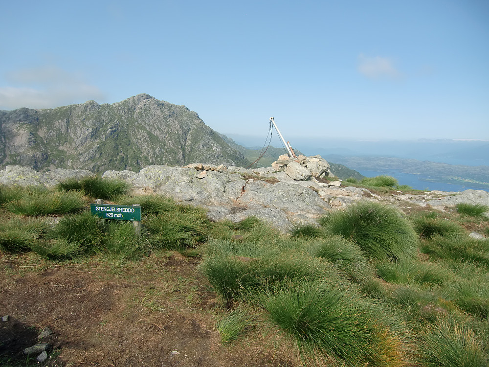 Steingildshøgda, skiltet Steingjelsheddo. Begge navn er navnsatt i Norgeskart. Stovegolvet i bakgrunnen.