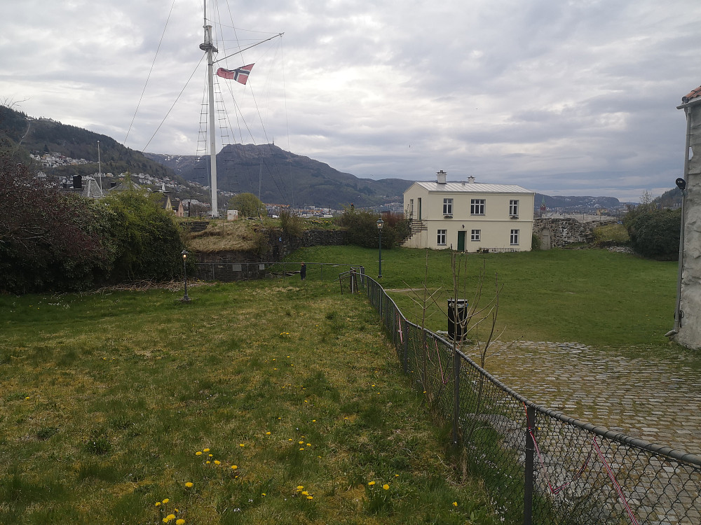 Søylen står bak huset oppe på vollgraven. 