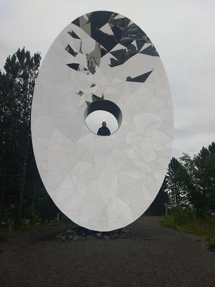 Brynhild kikker gjennom kunstverket "Eye of the North".