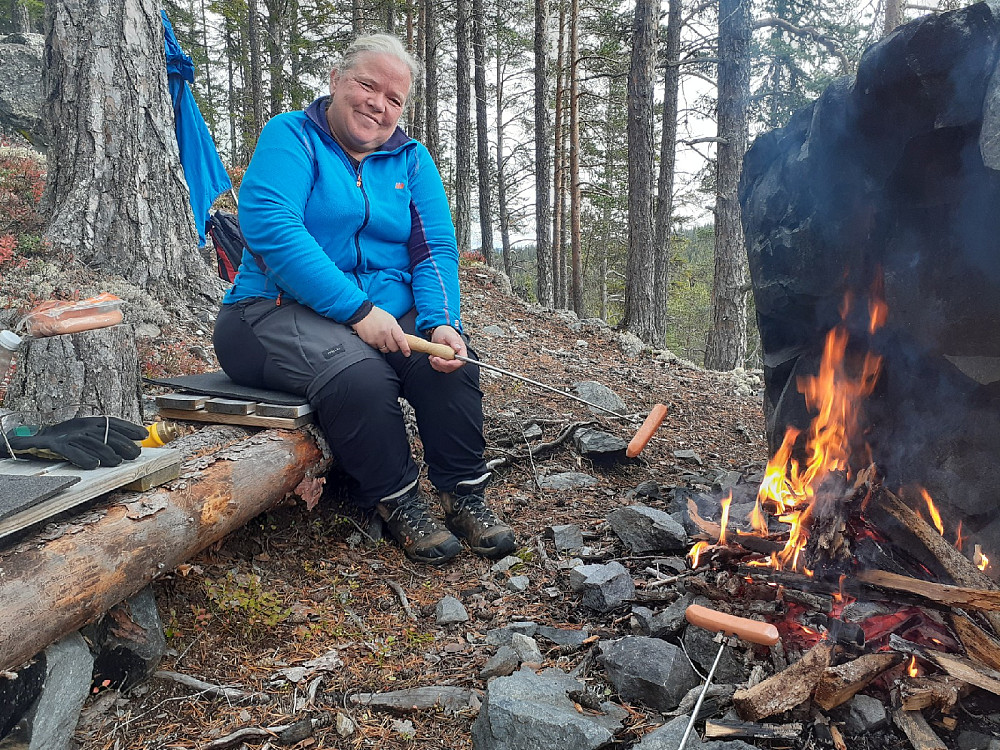 Fruen nyter bål og pølser.