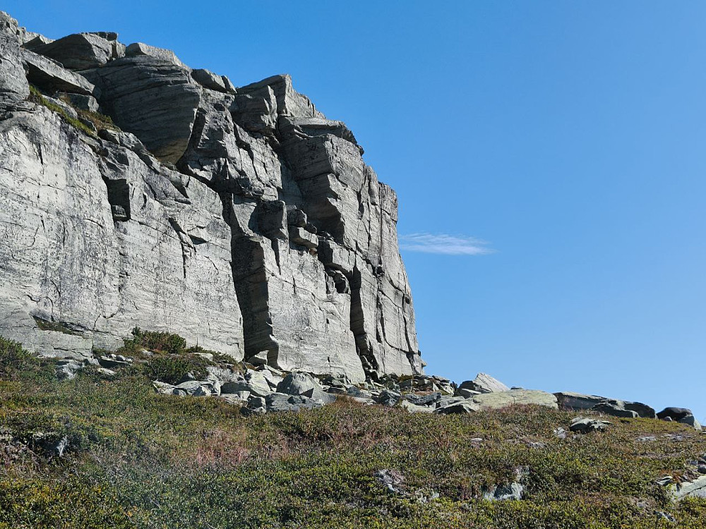 Grotta ligger i sørveggen rett under toppen av Heklefjell. (Sprekken midt i bildet.) 
