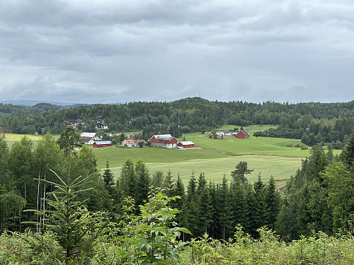 Tilbakeblikk mot gården og parkeringslomma ved hovedveien.