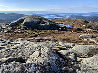 Utsikt fra toppen med rester av gammelt trig-punkt. Vi ser den nesten like høye toppen med en liten varde og lenger nede utsiktsvarden..