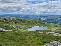 Utsikt fra 1056-toppen mot sørøst. Det blankskurte fjellet litt til høyre for midten er Storetofjellet ved Ånebjør. Helt til venstre i bildet skimtes Juvatn ved Bortelid.