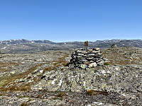 Varden på topp 1365. Til venstre ser vi Trollaskeinuten og Ikastenuten. Til høyre ser vi Kistenuten, Vassdalseggen og Fitjanuten.