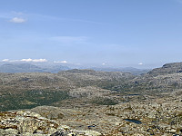 Utsikt mot nordøst. Litt disig vær. Men vi ser, fra venstre, Mælen, Trollaskeinuten, Grønenuten med Kvanndalen bak, og Fitjanuten. Helt til høyre Krokvassnutane. (Kistenuten og Vassdalseggen kan såvidt skimtes i disen midt i bildet).