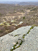 Grensen mellom Farsund og Lyngdal synes å følge sprekken i steinblokka. Det høyeste punktet er markert med tre små steiner.