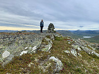 Toppen med Væringsvatnet bak til høyre. Bak Væringsvatnet stikker Skyvassnuten opp i horisonten.(Under den lille skya).