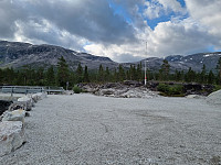 Her er jeg på 680 m og har gått 2,5 kilometer på grusvei og er klar til å forlate stien. Broen til venstre går over Grodjyvo som jeg skal følge til Grodjyvevatnet.