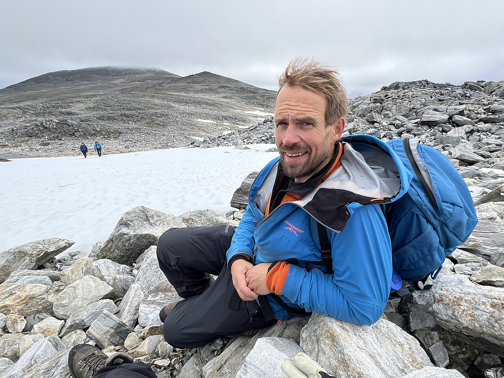 Frode tar en velfortjent pust mens vi venter på de to siste etter å ha krysset et snøfelt. Moldulhøi og 1931-toppen i bakgrunnen.