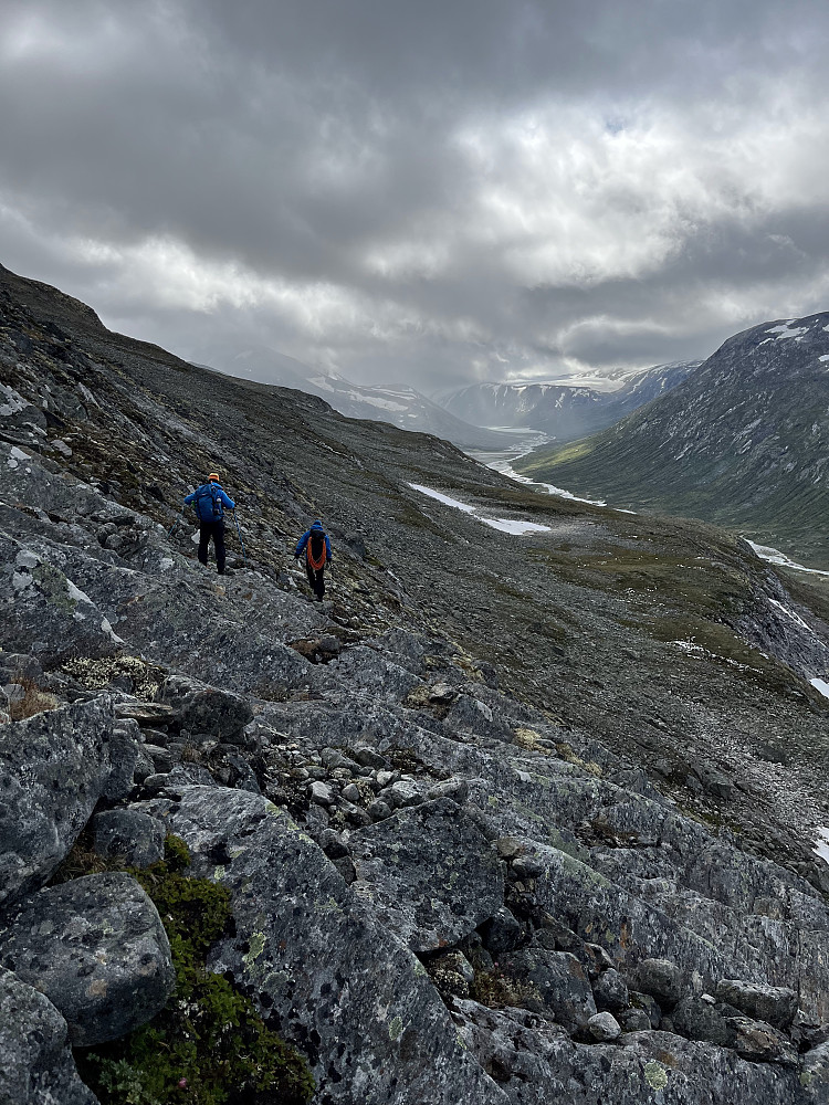 Vi søker nedover i fjellsiden etter enkleste nedfart, og må traversere litt vestover og innover i dalen for å finne en løsning.