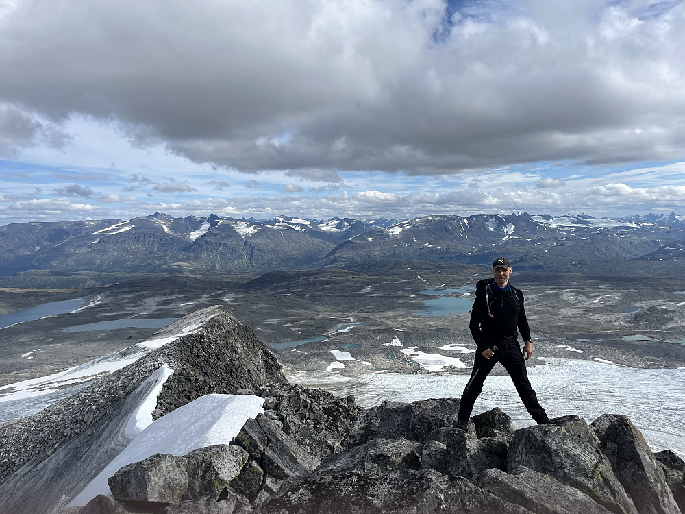Her er vi nå litt ute på Utløyparen og skal straks ned snørennene. Rett bak meg ligger kolossen Loftet og Storebjørn er lett synlig litt lengre mot høyre. Til venstre i bildet er det enkelt å plukke ut blant annet Galdhøpiggen og Skarstind.