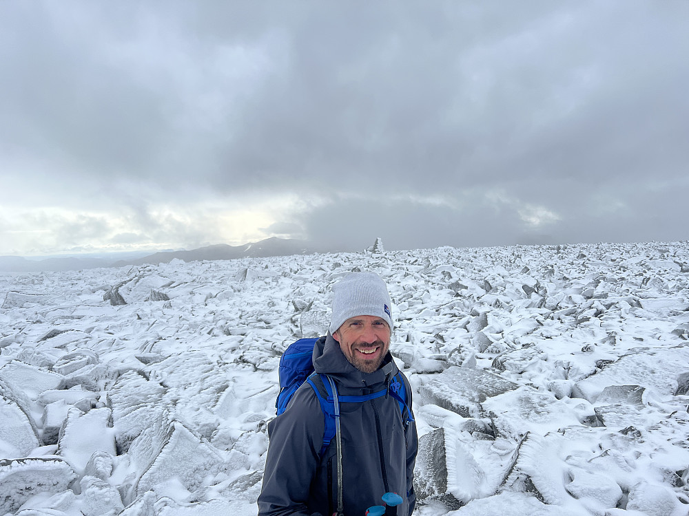 Frode smiler bredt på toppen av Trollsteinshøe. Veldig rundt og flatt på topplatået her, hvor det har kommet noe nysnø.