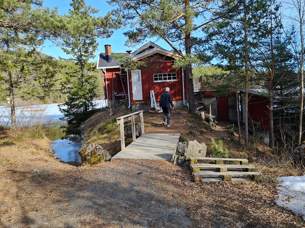 Den første hytta i Finnemarka, bygd av Hans Lysager, oldebarnet Hanne foran hytta