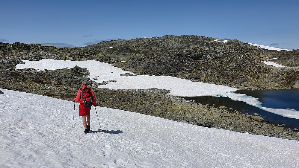 Erling krysser en snøfonn med Haldalshøgdi (1764) i sikte. Toppvarden kan så vidt skimtes foran en liten skydott litt til venstre for midten av bildet.