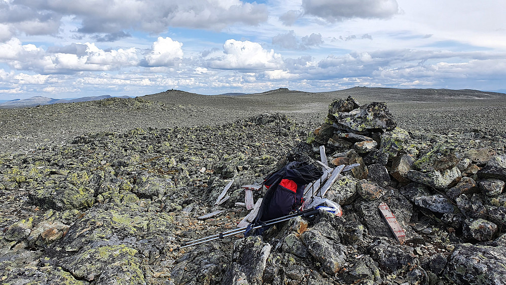 Varden og rester etter trig.punktet på Reineskarvet V2, som er litt over 1788 moh. I bakgrunnen er de tre andre jevnhøye steinhaugene.