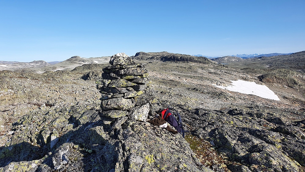 Nærmest er toppvarden på Gråhyrneran Sør (1714). Bak og midt i bildet er Gråhyrneran (1773). Jotunheimen kan ses i det fjerne til høyre.