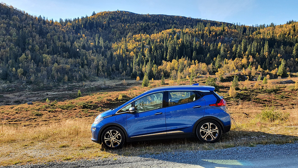 Parkering på bred veiskulder der det går en kort veistubb nedover. I bakgrunnen er Langfjellet (1089).