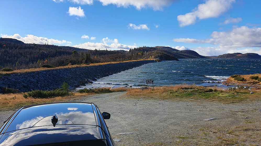 Parkeringen ved Røungsdammen, som ses på venstre side av bildet. Innsjøen Rødungen er til høyre. Bakerst og litt til høyre i bildet ses Åshovda (1102).